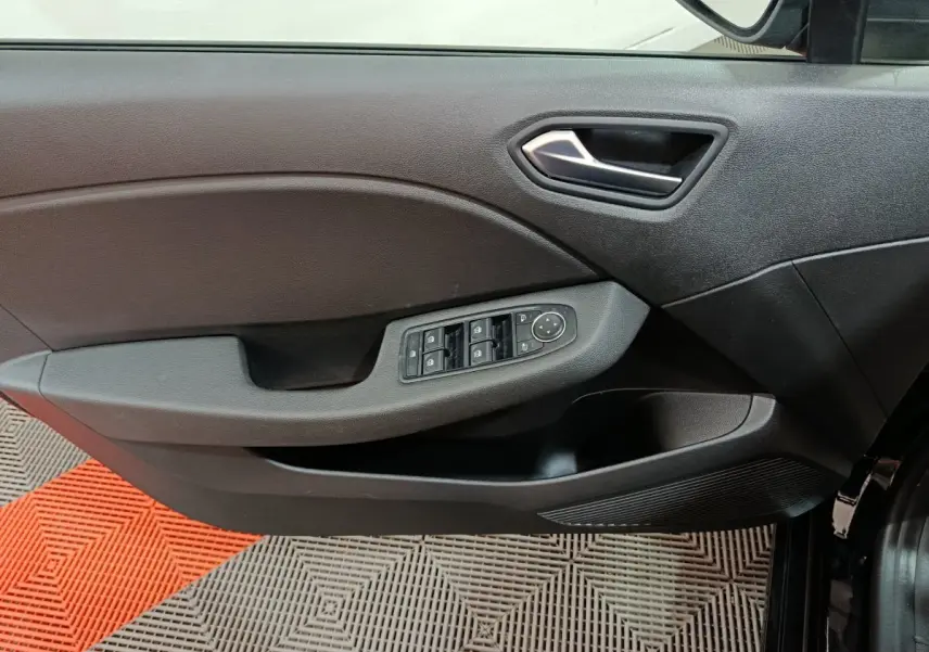 Vue rapprochée de la porte côté gauche noire de la Renault Clio Evolution Blue dCi 100 avec commandes des vitres et rétroviseurs.