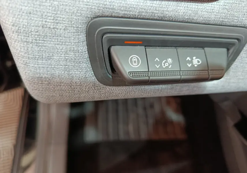 Boutons de réglage d'éclairage et verrouillage sur tableau de bord gris clair d'une Renault Clio Evolution Blue dCi 2025.