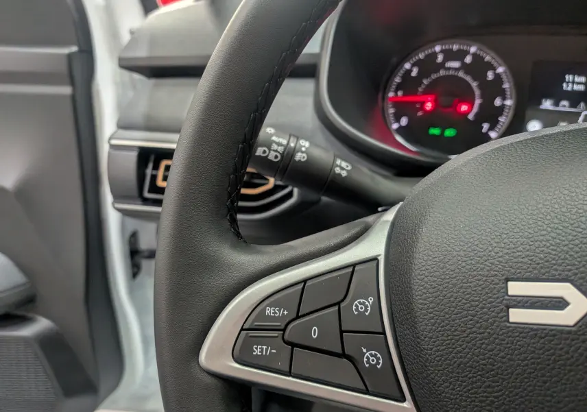 Gros plan sur le volant noir de la Dacia Sandero Stepway 2025, montrant les commandes de régulateur de vitesse.