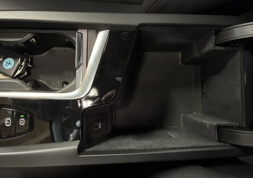 Vue rapprochée de la console centrale noire laquée du Volvo XC60 avec porte-clés et commandes de frein à main.