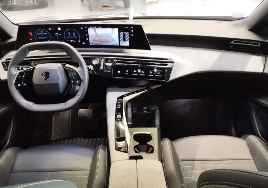 Vue intérieure avant du Peugeot 3008 2024 avec i-Cockpit panoramique, écran incurvé et sellerie gris clair.