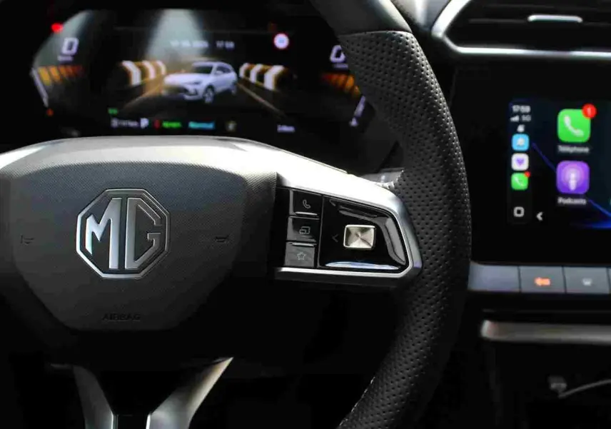 Vue rapprochée du volant perforé MG ZS 2026 avec commandes intégrées et tableau de bord numérique lumineux.