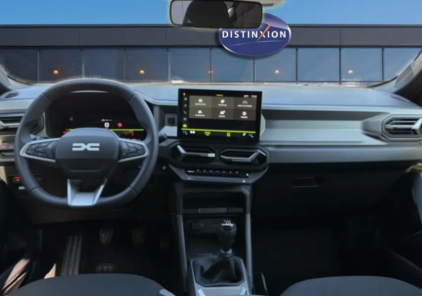 Vue intérieure avant du tableau de bord et volant multifonction du Dacia Bigster blanc, avec écran tactile et boîte manuelle.