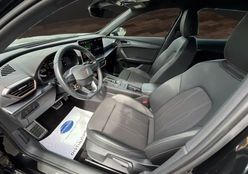 Vue intérieure côté conducteur du CUPRA Formentor 2025 avec sièges noirs et tableau de bord moderne à écran tactile.