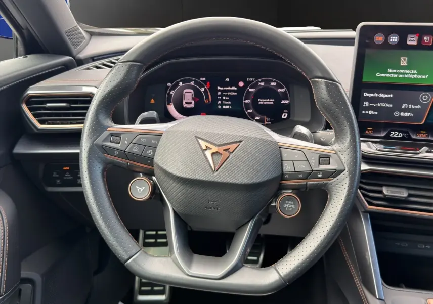 Vue rapprochée du volant en cuir perforé noir avec logo CUPRA cuivré et tableau de bord numérique du Formentor 2025.