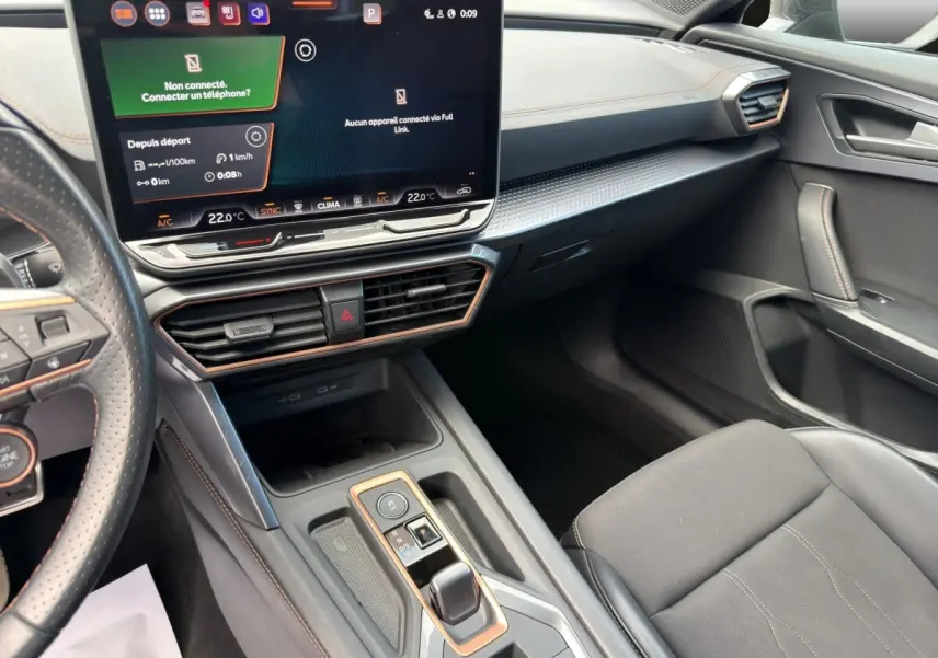 Intérieur noir du CUPRA Formentor 2025 vu côté passager, avec écran tactile central et volant cuir perforé.