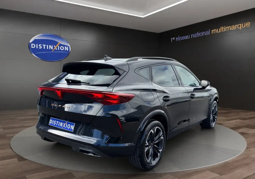Vue 3/4 arrière droite d'un CUPRA Formentor noir brillant avec feux arrière LED distinctifs en showroom.