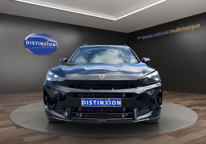 Vue avant d'un CUPRA Formentor noir brillant avec logo cuivré, dans un showroom au sol en parquet.