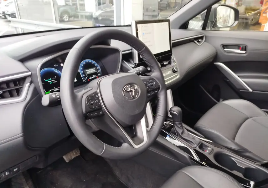 Vue intérieure côté conducteur de la Toyota Corolla Cross Hybrid 140 Luxury Limited 2025 avec tableau de bord numérique et écran tactile central.