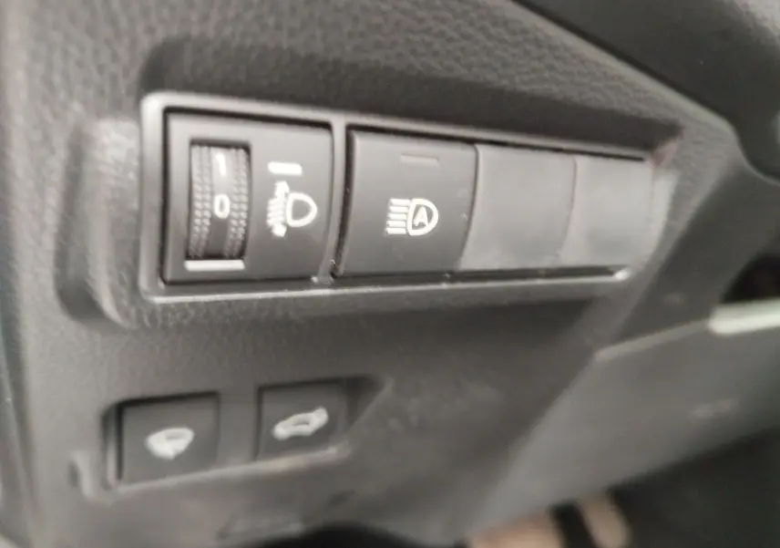Gros plan sur les commandes d’éclairage et ouverture du coffre du Toyota Corolla Cross Hybrid 140 Luxury Limited 2025.