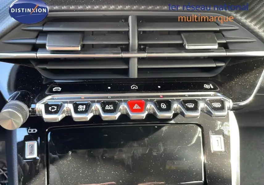Vue rapprochée de la console centrale du Peugeot 2008 gris Artense, montrant les commandes climatisation et boutons fonctionnels.