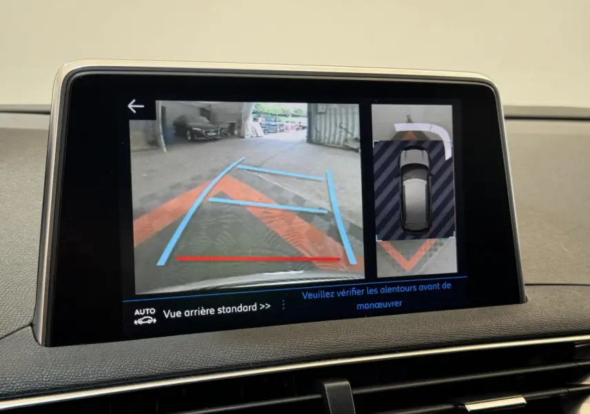 Écran tactile intérieur du Peugeot 3008 blanc montrant la caméra de recul avec guidage et vue 360° en stationnement.