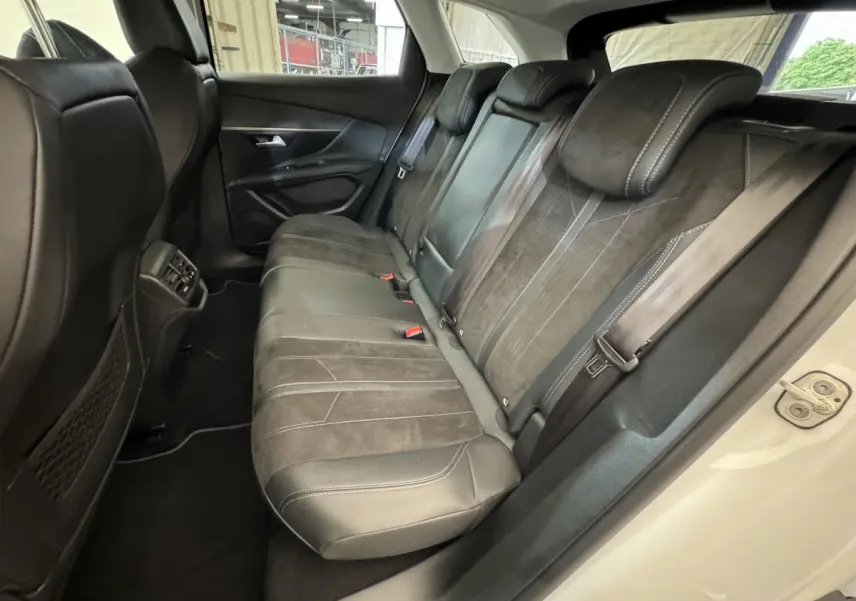 Vue côté droit des sièges arrière en cuir noir et alcantara du Peugeot 3008 blanc, avec ceinture de sécurité et appuie-têtes visibles.