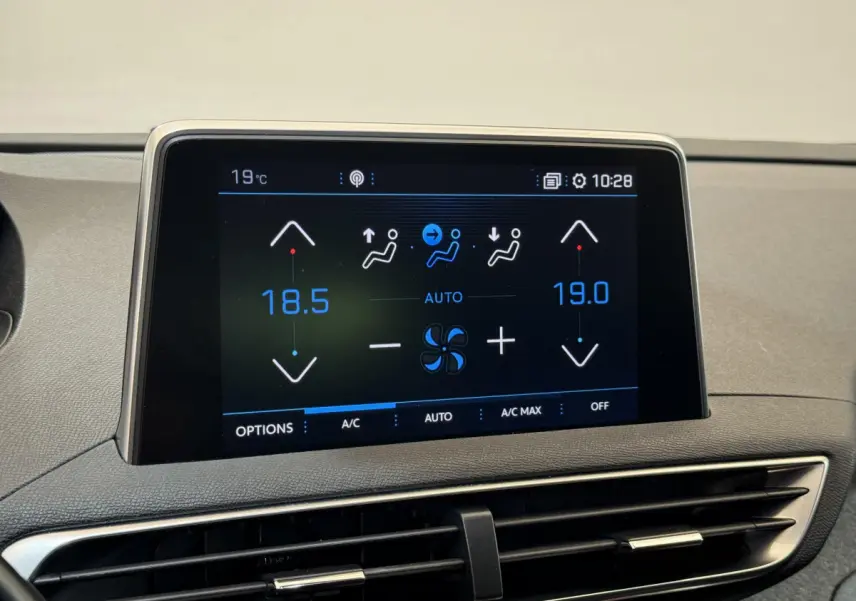 Écran tactile central affichant la climatisation bi-zone dans l'habitacle d'un Peugeot 3008 blanc, vue rapprochée.