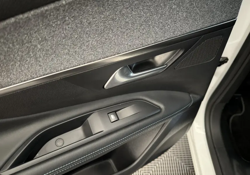 Gros plan sur la porte avant gauche blanche du Peugeot 3008 2019, avec garniture noire et surpiqûres bleues.