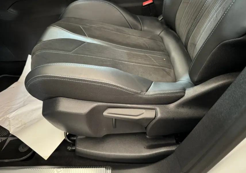 Gros plan sur le siège avant droit en cuir noir et alcantara du Peugeot 3008 Crossway blanc, avec levier de réglage manuel visible.