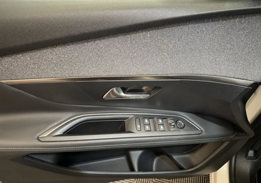 Gros plan sur la porte côté conducteur du Peugeot 3008 blanc, montrant les commandes des vitres et le revêtement noir.