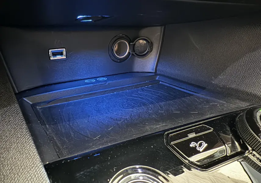 Gros plan sur la console centrale noire du Peugeot 3008 blanc, montrant prise USB, allume-cigare et commande de descente assistée