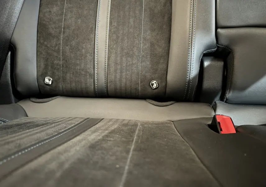 Gros plan sur la banquette arrière en cuir et alcantara noir du Peugeot 3008 Puretech 130 Crossway, avec ceintures visibles.
