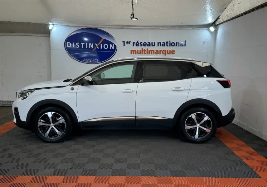 Profil droit d'un Peugeot 3008 blanc avec toit noir et jantes alliage bicolores dans un showroom.