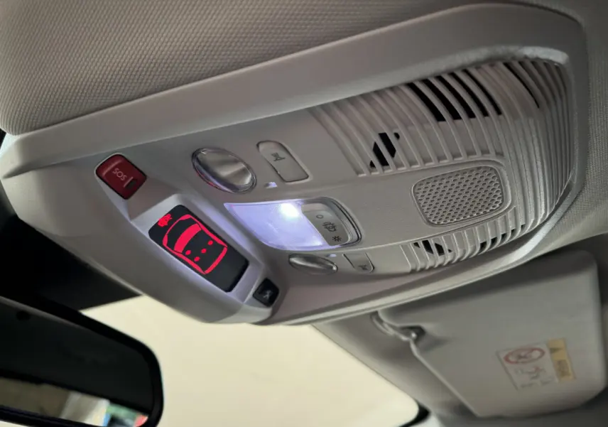 Vue intérieure en gros plan du plafonnier gris avec commandes lumineuses et bouton SOS du Peugeot 3008 blanc 2019.