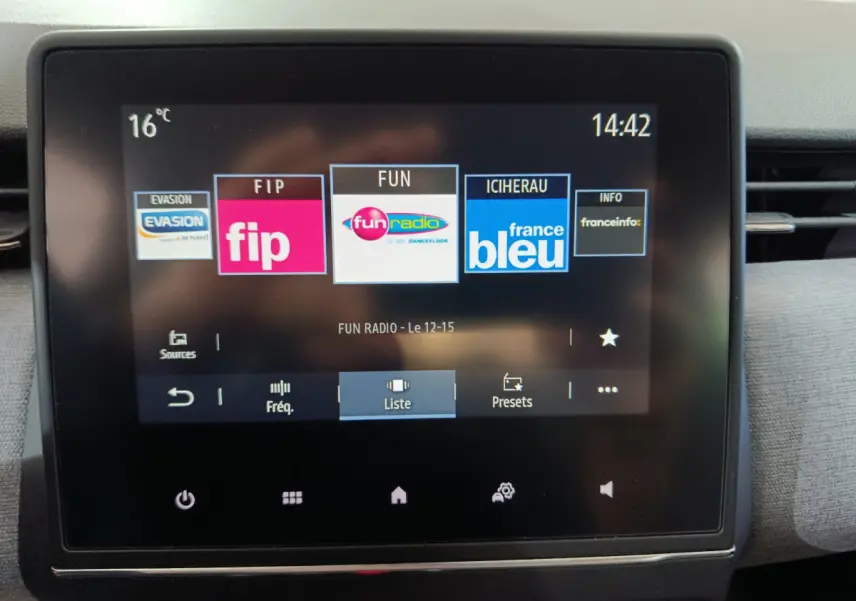 Écran tactile central de 7 pouces affichant les stations radio dans l'habitacle d'une Renault Clio gris foncé 2025.