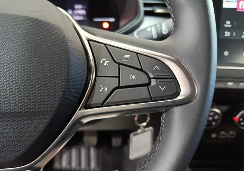 Gros plan sur les commandes multifonctions du volant cuir de la Renault Clio gris foncé Evolution Blue dCi 100 2025.