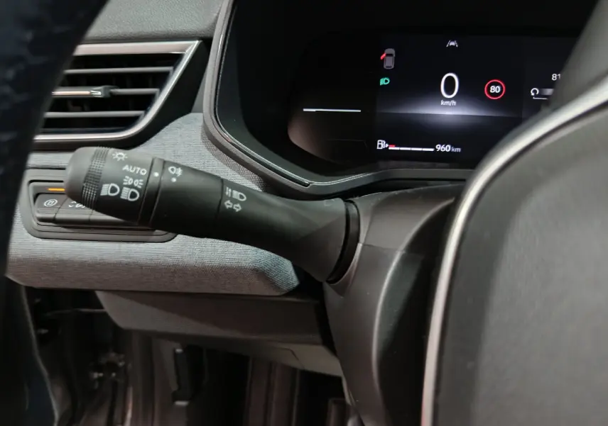 Gros plan sur la commande des phares et le combiné d'instruments digital de la Renault Clio Evolution Blue dCi 100 gris foncé.