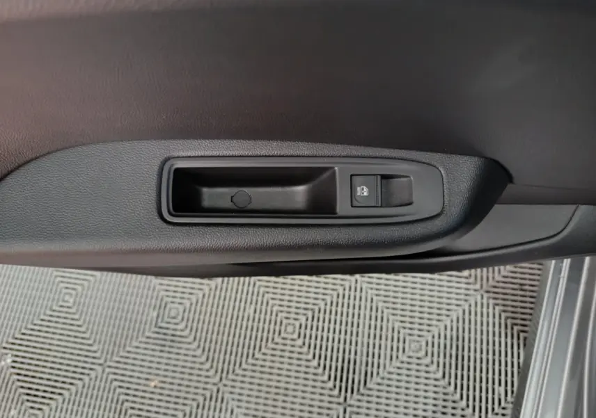 Bouton de verrouillage centralisé sur la porte intérieure côté conducteur d'une Renault Clio gris foncé.