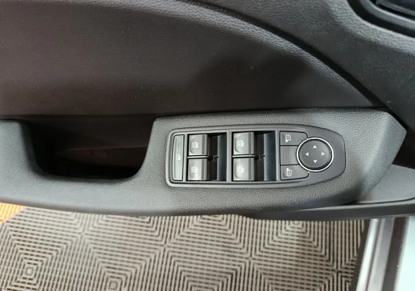 Commande des vitres et réglage des rétroviseurs côté conducteur sur porte intérieure noire d'une Renault Clio gris foncé 2025.