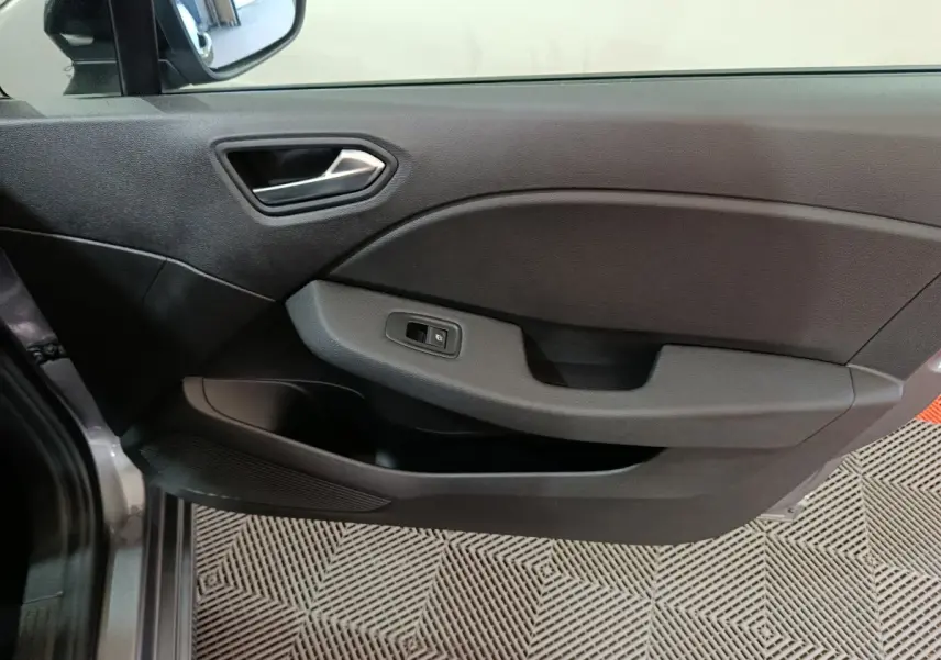 Vue côté gauche de la porte intérieure noire de la Renault Clio Evolution Blue dCi 100 -25 avec commande de vitre électrique.