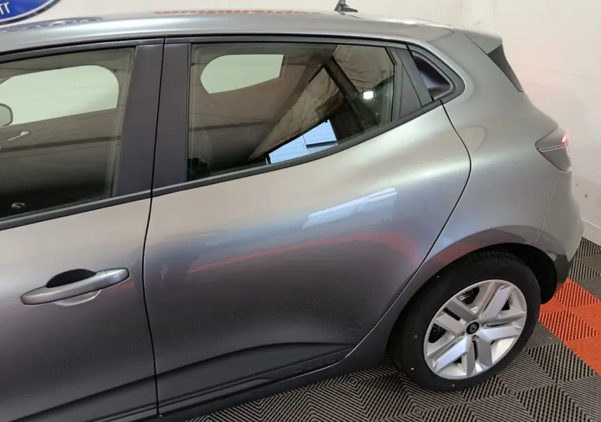 Profil côté gauche d'une Renault Clio gris foncé 2025, mettant en valeur la ligne fluide et la jante alliage distinctive.