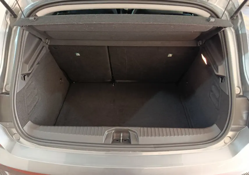 Coffre ouvert vu de l'arrière d'une Renault Clio gris foncé Evolution Blue dCi 100 -25, espace de chargement vide.