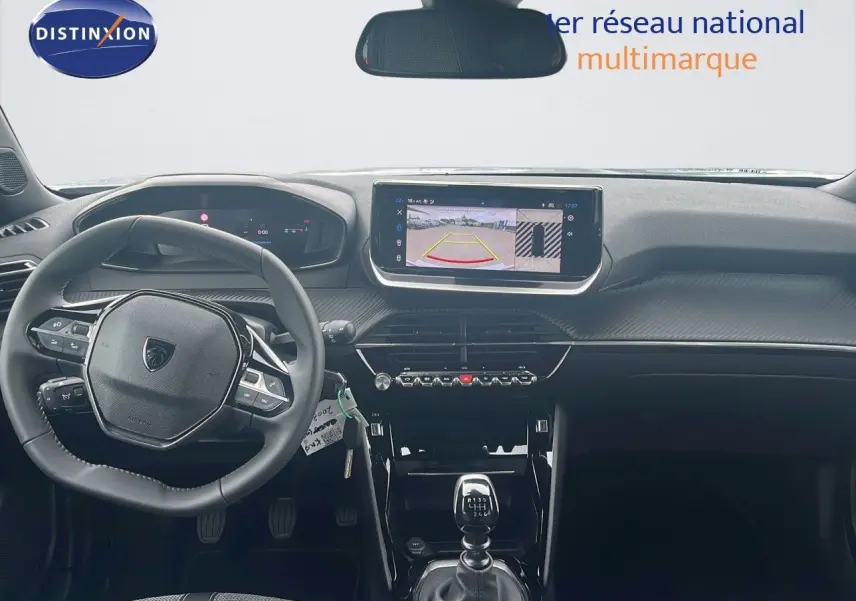 Intérieur du Peugeot 2008 2025 vu de face, tableau de bord noir avec écran tactile et levier de vitesse manuel.