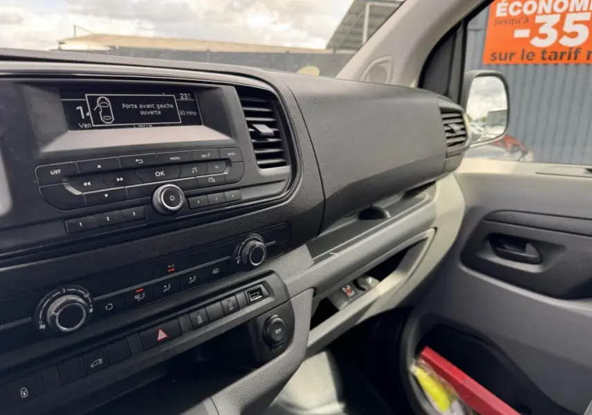 Tableau de bord et console centrale du Peugeot Expert Fourgon blanc, vue intérieure côté passager avec écran et commandes visibles.