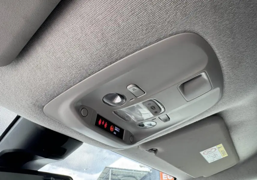 Vue intérieure du plafonnier gris clair du Peugeot Expert Fourgon blanc, avec commandes d'éclairage et affichage LED rouge.