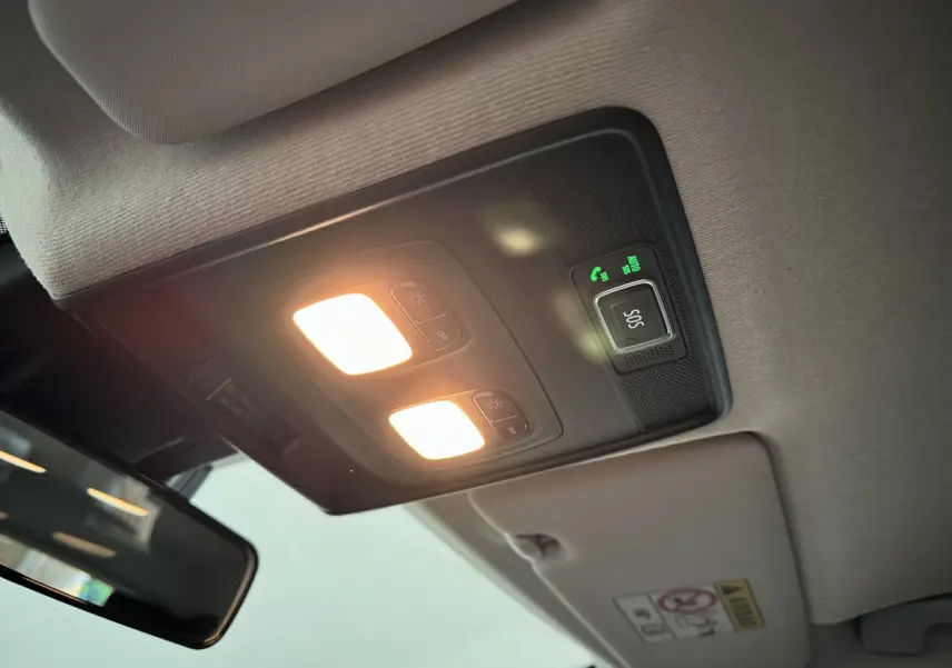 Vue intérieure du plafonnier avec éclairage allumé et bouton SOS de la Renault Clio gris clair 2025.