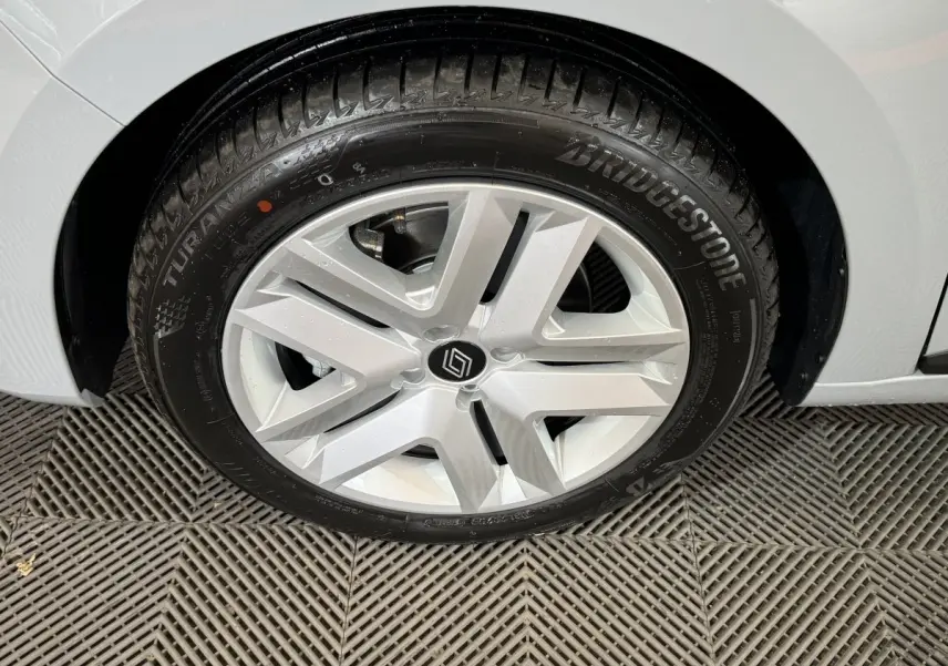 Gros plan sur la roue avant droite d'une Renault Clio gris clair avec jante alliage et pneu Bridgestone.