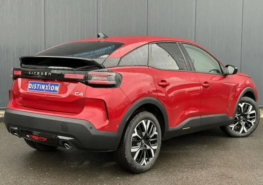 Vue 3/4 arrière droite d'une Citroën C4 Rouge Elixir avec jantes alliage 18'' et feux arrière LED distinctifs.