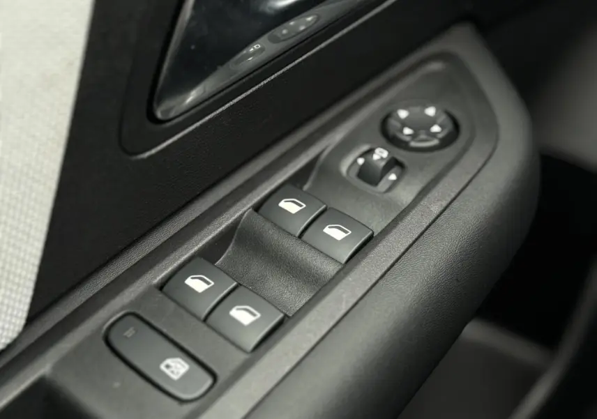 Gros plan sur les commandes de lève-vitres et rétroviseurs côté gauche de la porte intérieure d'une Citroën C4 Hybrid 2025.