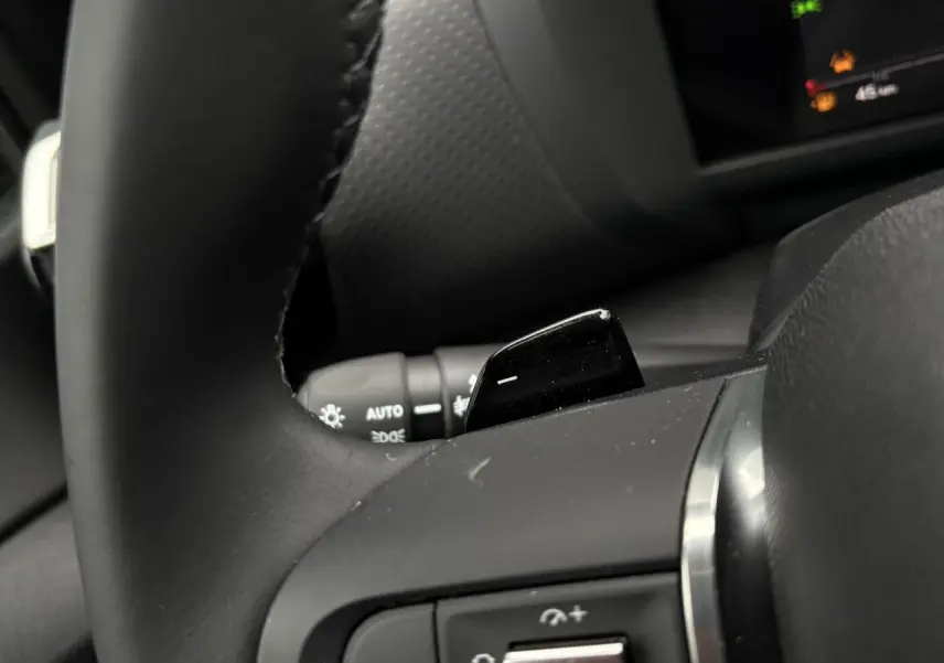 Gros plan sur la palette de changement de rapport au volant cuir noir du Citroën C4 Hybrid 2025.