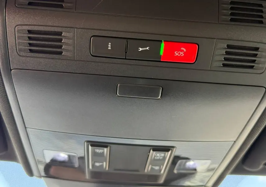 Vue en contre-plongée du plafonnier noir avec boutons SOS et commandes d’éclairage intérieur du Volkswagen Taigo gris.