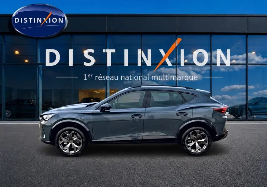 Vue de profil côté gauche d'une CUPRA Formentor 1.5 etsi hybrid 2026 en bleu fjord devant une vitrine Distinxion.