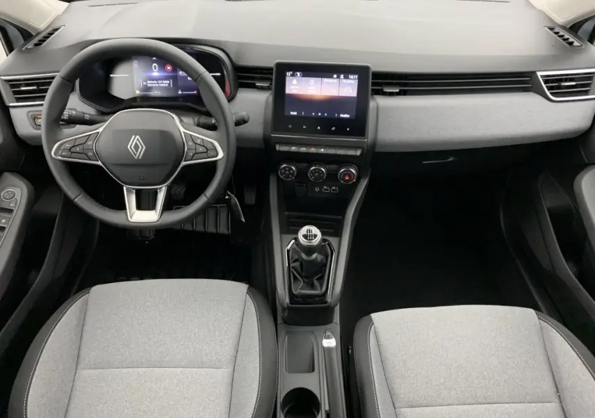 Vue intérieure avant de la Renault Clio V TCE 90 avec tableau de bord noir, volant multifonction et sellerie textile grise.