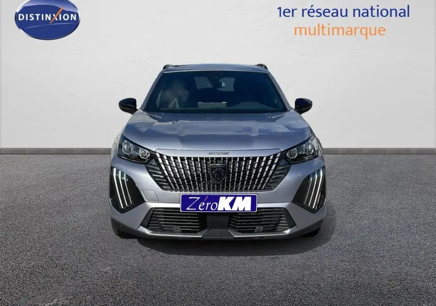 Peugeot 2008 gris Artense métal vue de face, avec calandre distinctive et feux LED verticaux allumés.