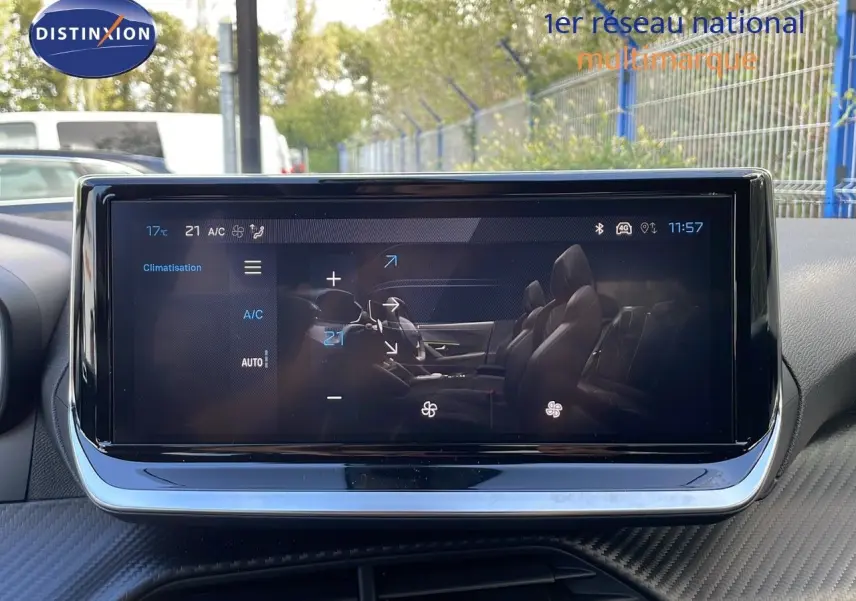 Écran tactile central du Peugeot 2008 2025 affichant la climatisation, avec reflet des sièges en cuir noir.