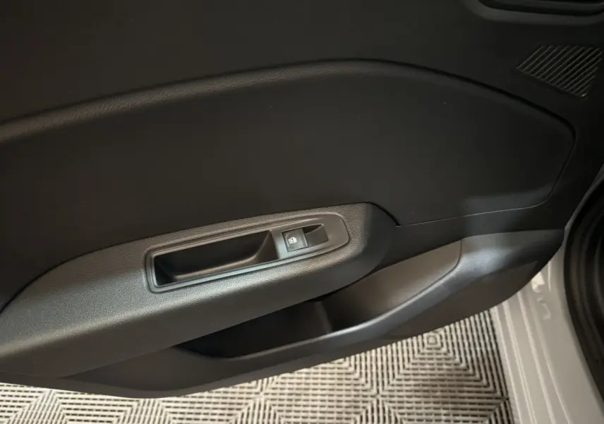 Gros plan sur la porte côté droit de la Renault Clio gris clair 2025, montrant la commande de verrouillage des portes.