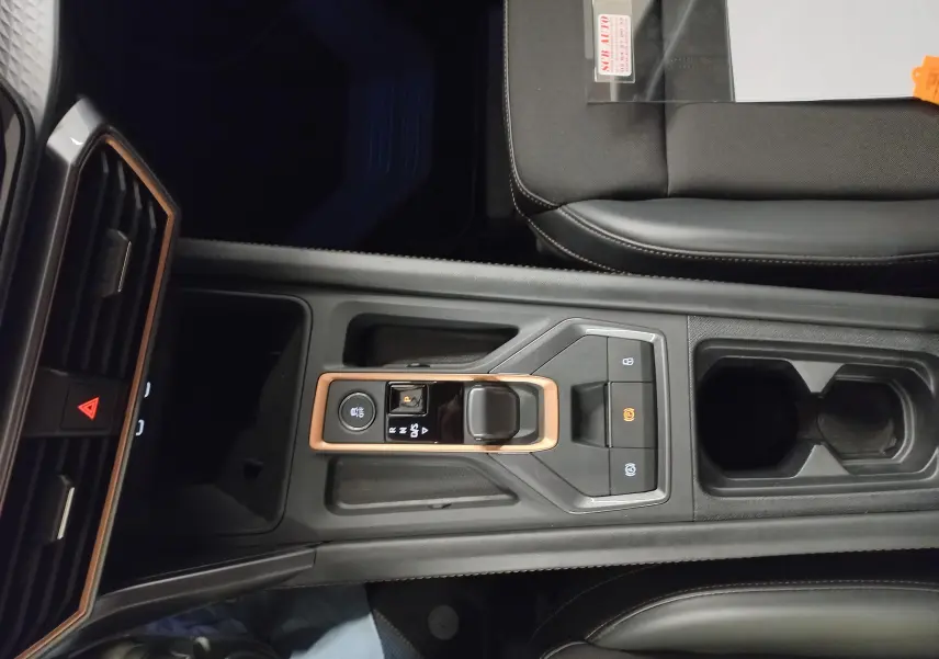 Vue plongeante sur la console centrale de la CUPRA Leon 2025, avec levier de vitesse DSG7 et finitions cuivrées.