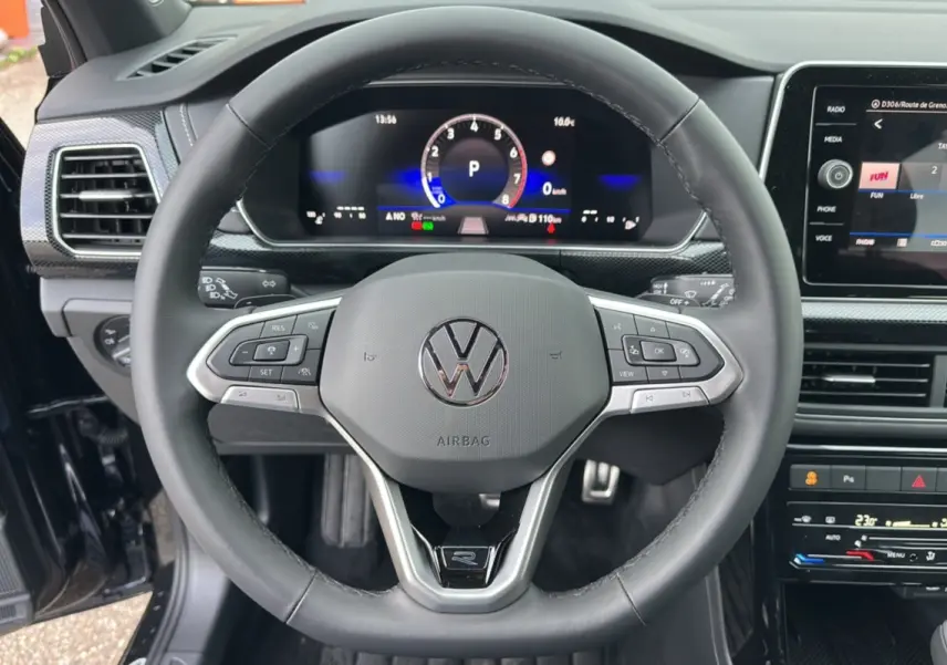 Vue rapprochée du volant cuir multifonctions et du tableau de bord numérique du Volkswagen T-Cross noir intense 2025.