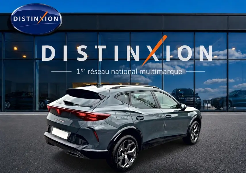 Vue 3/4 arrière droite d’un CUPRA Formentor bleu fjord avec jantes 18 pouces, feu arrière LED et diffuseur noir.